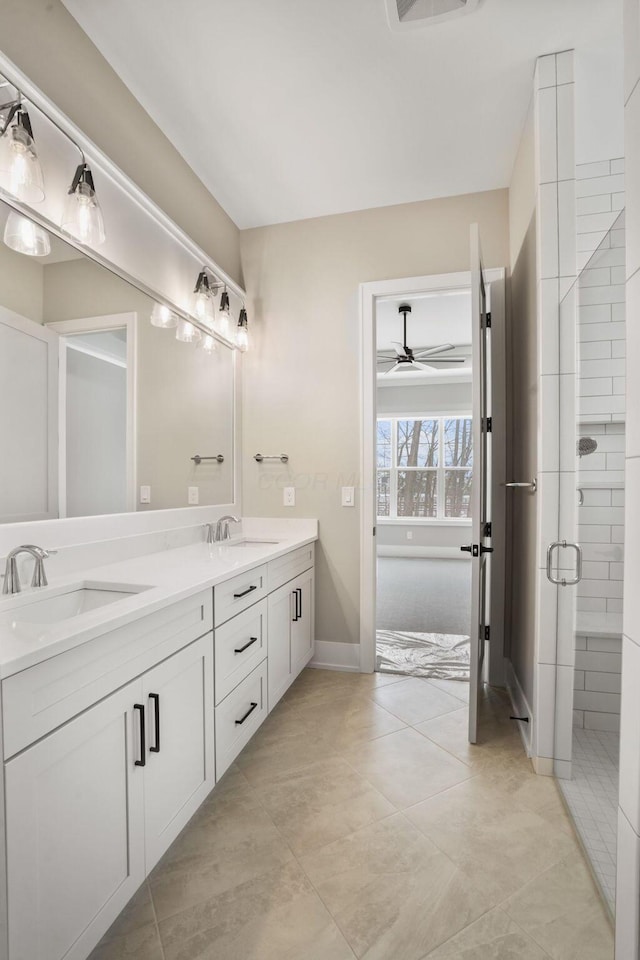 bathroom featuring double vanity, a stall shower, a ceiling fan, and a sink