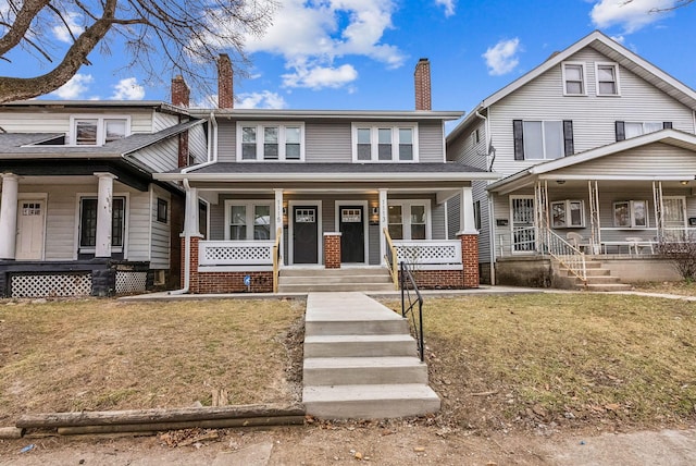 view of front of home featuring a chimney, a front lawn, and a porch