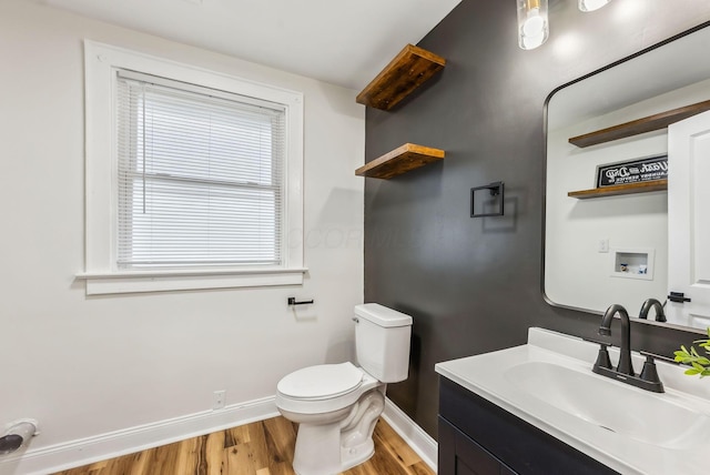 bathroom with baseboards, vanity, toilet, and wood finished floors