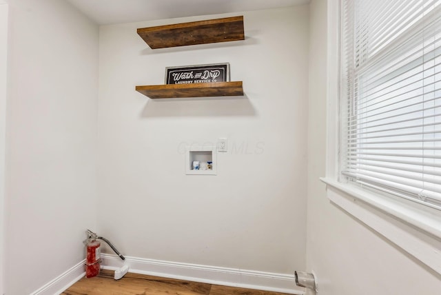 clothes washing area featuring laundry area, hookup for a washing machine, baseboards, and wood finished floors