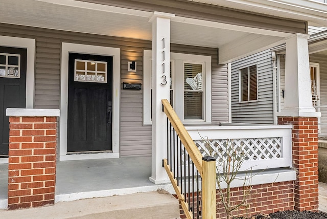 entrance to property featuring brick siding and a porch