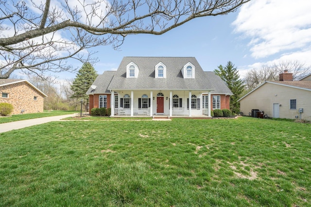 cape cod house with covered porch, a shingled roof, and a front yard