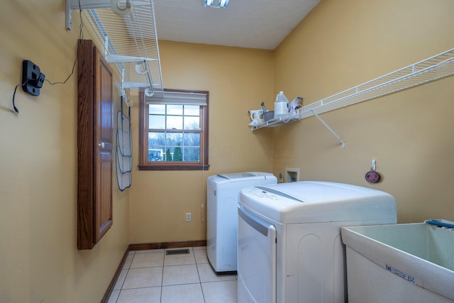 laundry area with washer and clothes dryer, light tile patterned floors, a sink, visible vents, and laundry area