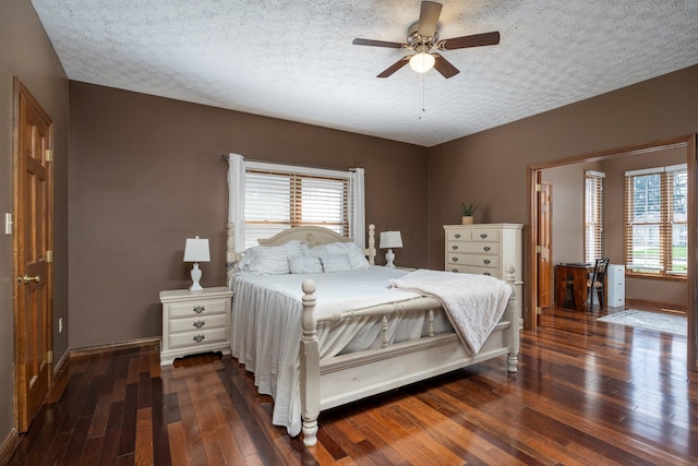 bedroom with hardwood / wood-style flooring, multiple windows, and a textured ceiling