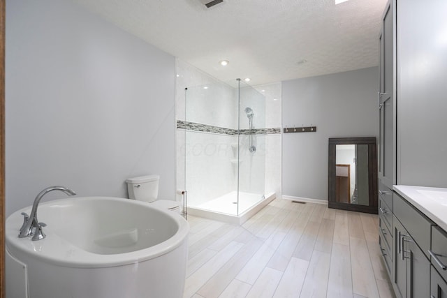 bathroom with tiled shower, vanity, a garden tub, wood finished floors, and a textured ceiling