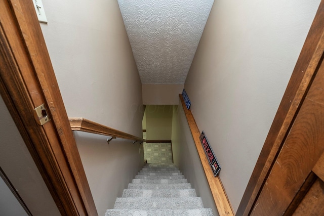 stairway with a textured ceiling