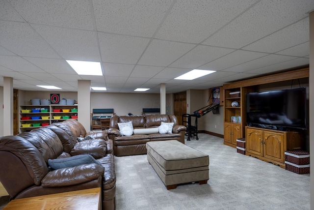living room featuring a drop ceiling and baseboards