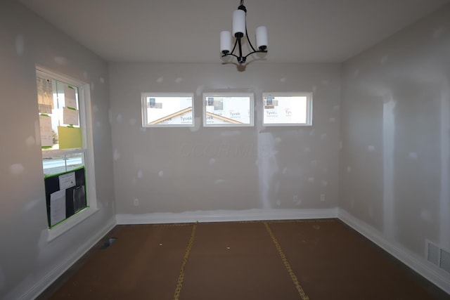 unfurnished dining area with a chandelier, visible vents, and baseboards