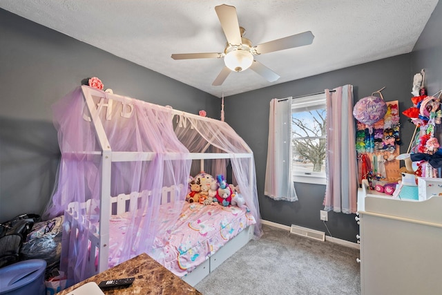carpeted bedroom featuring a ceiling fan, baseboards, visible vents, and a textured ceiling