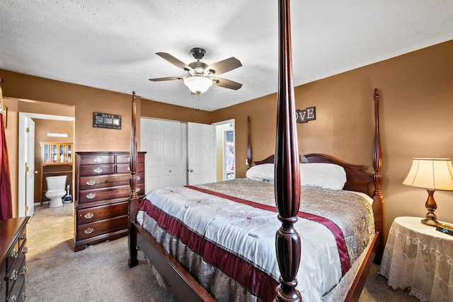 carpeted bedroom with a ceiling fan, a closet, and a textured ceiling