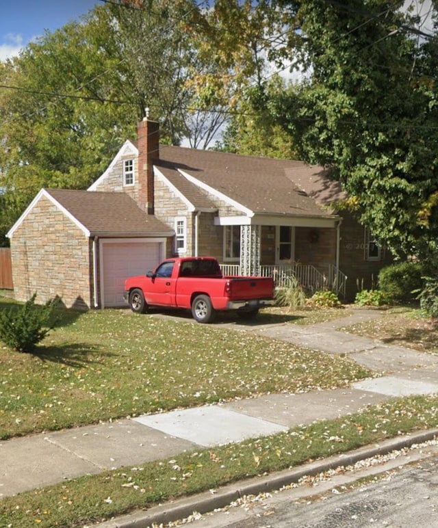 view of front facade with a garage, a front yard, stone siding, and a chimney