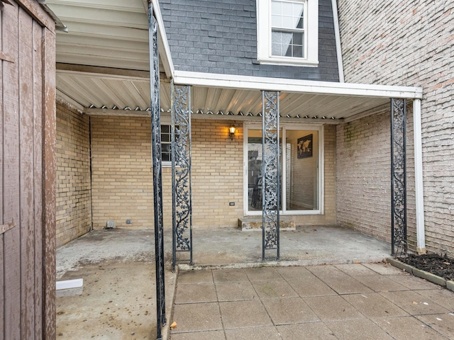 view of exterior entry with a patio