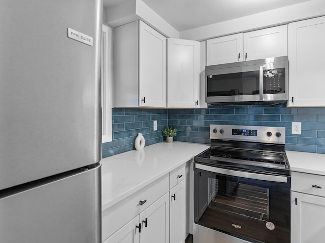 kitchen featuring appliances with stainless steel finishes, white cabinetry, and tasteful backsplash