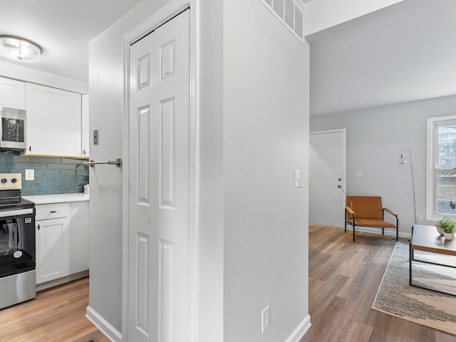 kitchen featuring white cabinetry, visible vents, appliances with stainless steel finishes, and light wood-style floors