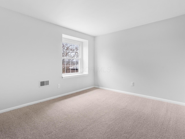 unfurnished room with carpet flooring, visible vents, and baseboards