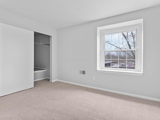 unfurnished bedroom with a closet, carpet flooring, visible vents, and baseboards