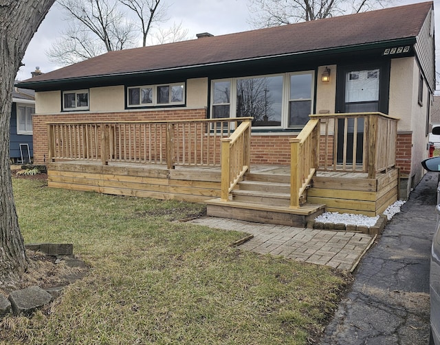 view of front facade with a front lawn, brick siding, and a chimney