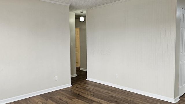 spare room with ornamental molding, baseboards, dark wood-style flooring, and a textured ceiling