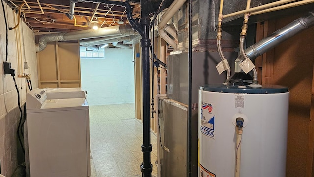 basement featuring tile patterned floors, washing machine and dryer, and water heater