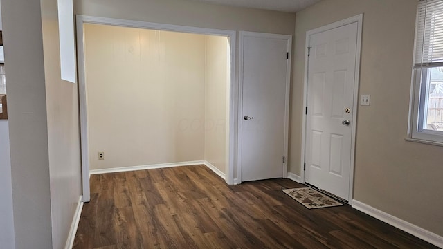 entryway with dark wood-style floors and baseboards