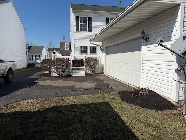 view of side of home featuring aphalt driveway