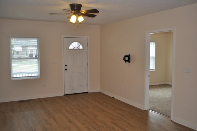 foyer entrance with baseboards, a ceiling fan, wood finished floors, and a healthy amount of sunlight