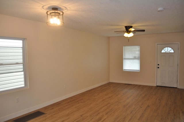 foyer entrance featuring baseboards, light wood-style flooring, visible vents, and ceiling fan
