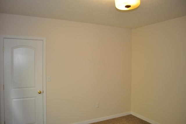 carpeted empty room with baseboards