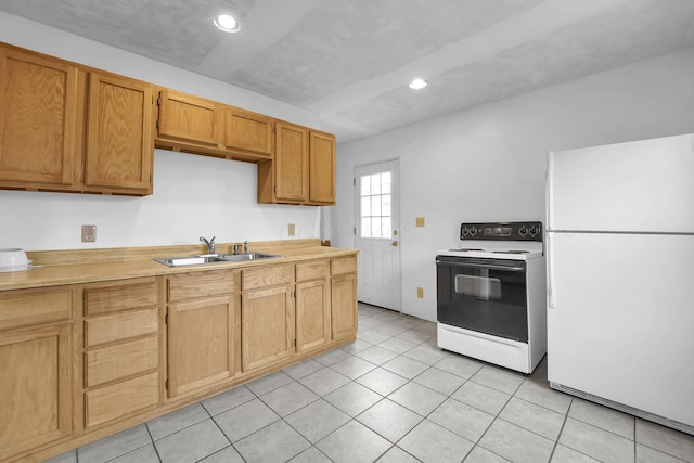 kitchen with a sink, light countertops, electric stove, and freestanding refrigerator