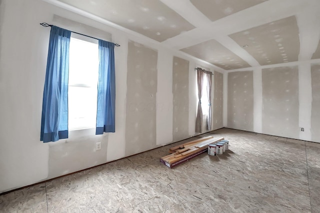 unfurnished room featuring coffered ceiling