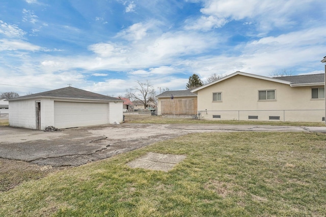 view of yard featuring a garage, fence, and an outdoor structure