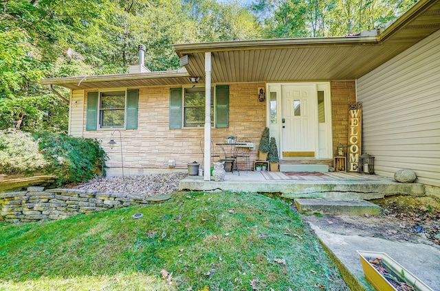 entrance to property with stone siding and a porch