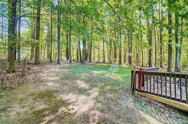 view of yard with a view of trees and a wooden deck