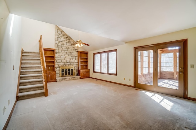 unfurnished living room featuring vaulted ceiling, stairway, carpet flooring, and a fireplace