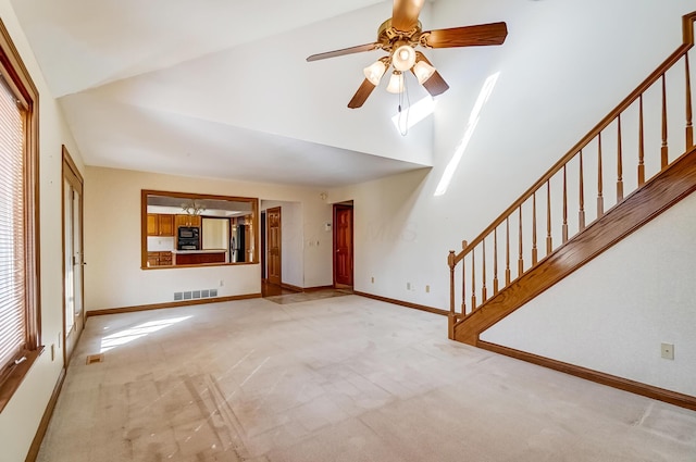 unfurnished living room with a ceiling fan, light colored carpet, visible vents, and baseboards