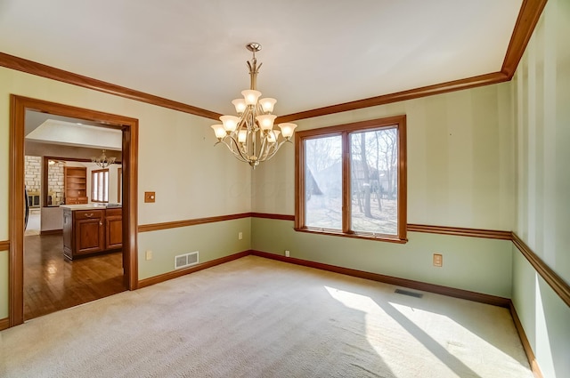 carpeted empty room featuring visible vents, a notable chandelier, and crown molding