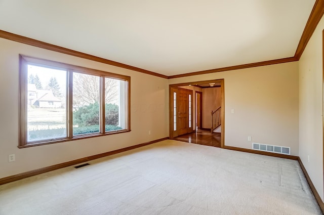 empty room featuring carpet, visible vents, and ornamental molding