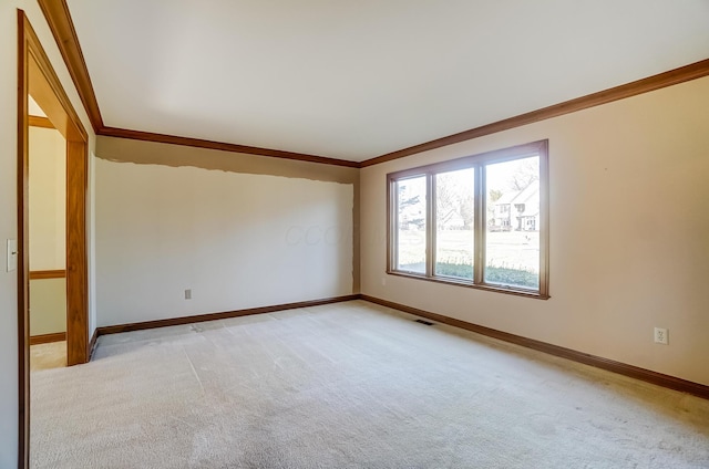 empty room with light carpet, visible vents, crown molding, and baseboards