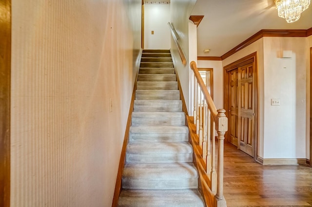 stairs featuring crown molding, baseboards, and wood finished floors