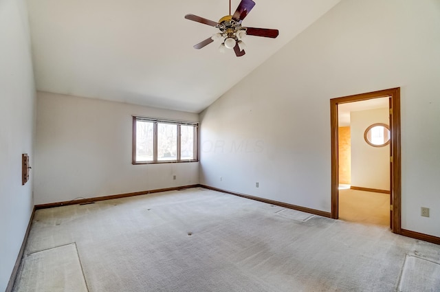 spare room featuring visible vents, baseboards, high vaulted ceiling, ceiling fan, and light carpet