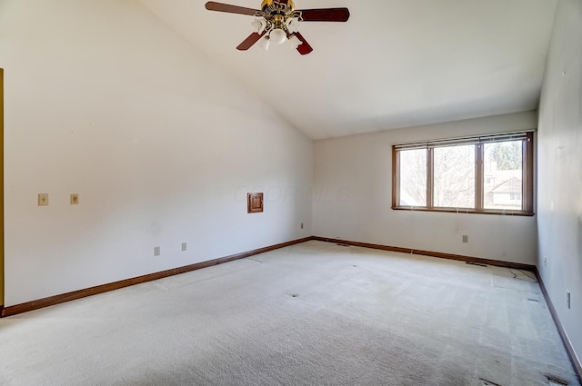 empty room with vaulted ceiling, a ceiling fan, baseboards, and light carpet