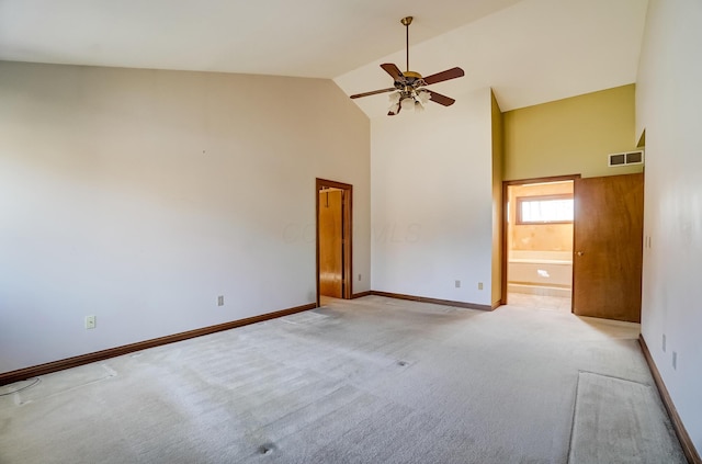 empty room with light carpet, visible vents, high vaulted ceiling, and baseboards