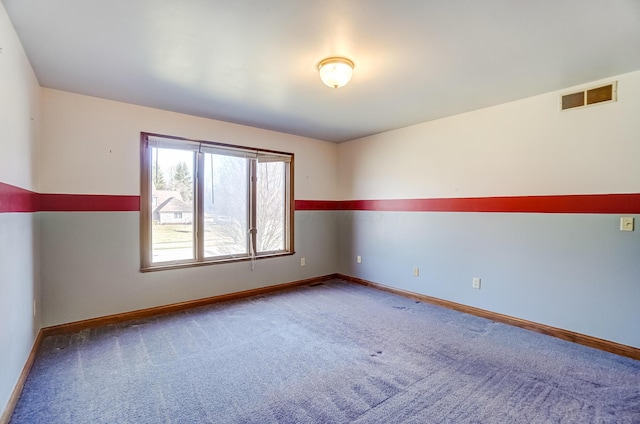 spare room with visible vents, baseboards, and carpet