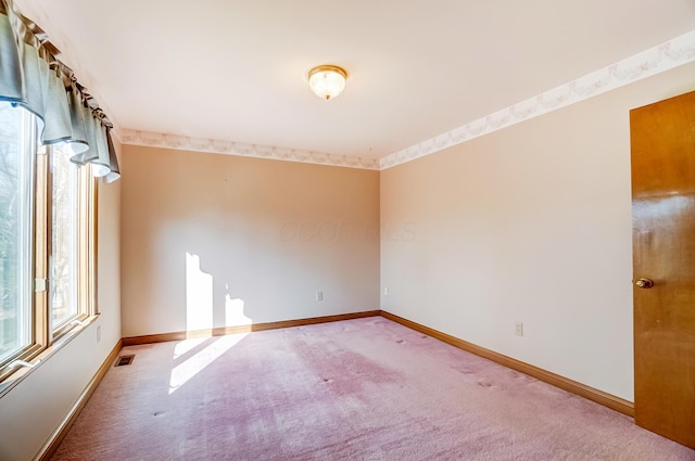 carpeted empty room with visible vents and baseboards