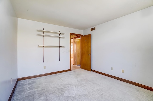 unfurnished room with visible vents, baseboards, and carpet floors