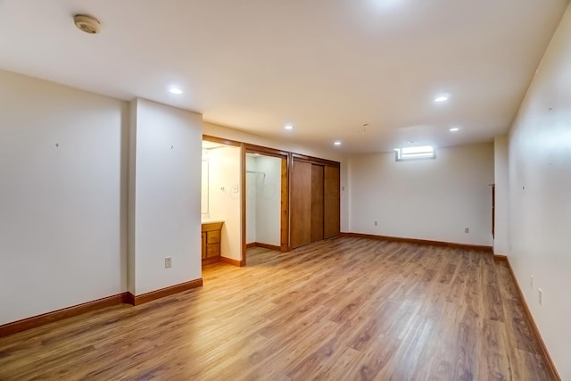 below grade area featuring recessed lighting, light wood-style flooring, and baseboards