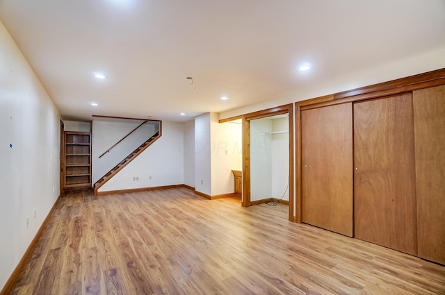 finished below grade area featuring recessed lighting, stairs, light wood-type flooring, and baseboards