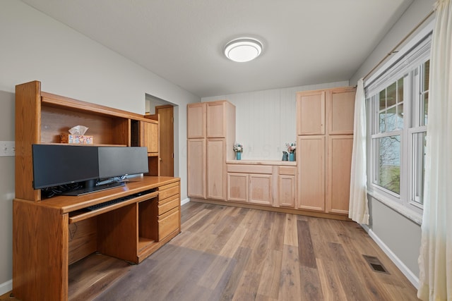 kitchen with light countertops, light wood finished floors, light brown cabinets, and visible vents