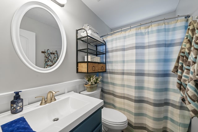 bathroom with curtained shower, vanity, and toilet