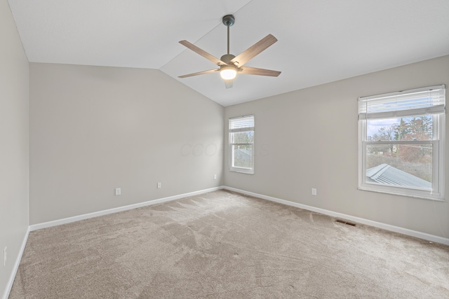 spare room featuring lofted ceiling, ceiling fan, visible vents, baseboards, and carpet